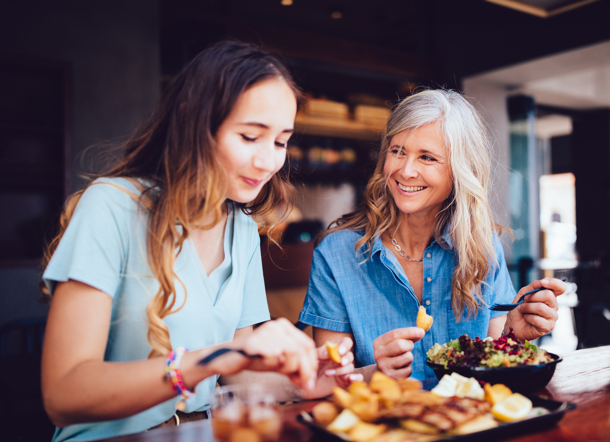 mother and daughter sitting down to have good together. They are smiling and happy