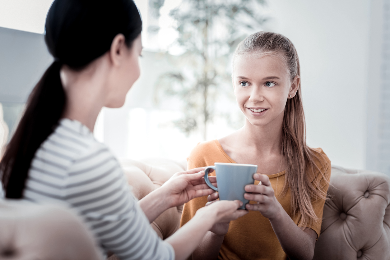 mother and teen having a meaningful conversation over coffee